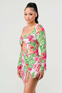 Colorful Floral Long Sleeve Mini Dress: This mini dress showcases a colorful floral print with shades of pink, green, and white. It includes long sleeves, a twist-front cut-out, and ruched side detailing with a drawstring.