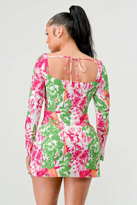 Floral Pattern Mini Dress with Twist-Front and Ruched Side: A mini dress adorned with a vivid floral pattern in pink, green, and white. It includes a twist-front cut-out, long sleeves, and side ruching with a drawstring.