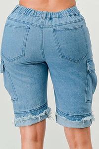 Denim Bermuda Shorts with Pockets: Casual light blue denim Bermuda shorts featuring cargo pockets and distressed areas. The shorts are finished with a rolled hem for a relaxed, fashionable style.