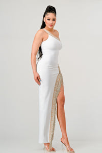 Elegant one-shoulder white gown with a gold embellished fringe, showcased by a model.