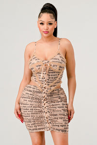 NEWSLETTER PRINT SEXY MINI DRESS
Model wearing a beige mini dress with a newspaper print, drawstring waist, and spaghetti straps. - Rêve Dorés