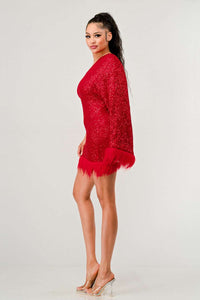 Azure Allure One-Shoulder Dress - Model wearing a glamorous one-shoulder mini dress in vibrant red, adorned with shimmering sequins and featuring a dramatic single sleeve. The hem and sleeve are accented with feathered detailing, adding a bold and luxurious touch, perfect for special occasions or holiday parties. -Rêve Dorés