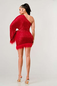 Azure Allure One-Shoulder Dress - Model wearing a glamorous one-shoulder mini dress in vibrant red, adorned with shimmering sequins and featuring a dramatic single sleeve. The hem and sleeve are accented with feathered detailing, adding a bold and luxurious touch, perfect for special occasions or holiday parties. -Rêve Dorés