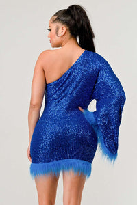 Model wearing a dazzling one-shoulder mini dress in vibrant blue, covered in shimmering sequins and featuring a dramatic single sleeve. The hem and sleeve are accented with matching feathered trim, creating a bold and luxurious look ideal for parties and special occasions - Rêve Dorés