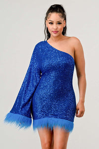 Model wearing a dazzling one-shoulder mini dress in vibrant blue, covered in shimmering sequins and featuring a dramatic single sleeve. The hem and sleeve are accented with matching feathered trim, creating a bold and luxurious look ideal for parties and special occasions - Rêve Dorés