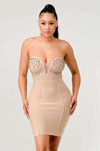 Glamorous tight-fitting nude dress with jewel-encrusted bust and a deep V-neckline, perfect for formal events.