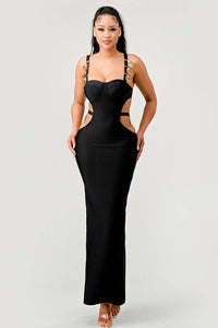 Elegant Black Maxi Dress with Side Cut-Outs: This elegant black dress showcases side cut-outs and gold-accented straps. The long, fitted silhouette creates a glamorous look for evening wear.