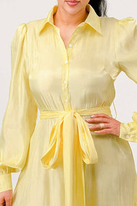 Flowy Yellow Ruffle Dress with Belt: A stylish yellow dress with a tiered ruffle skirt, long sleeves, and a collared neckline. The dress is complemented by a matching fabric belt at the waist. Rêve Dorés