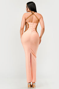 Peaches and Cream Infinity Gown Bandage dress Model wearing a sleek peach maxi dress featuring a halter neckline with contrasting brown trim accents that outline the curves, creating a sophisticated and contemporary silhouette. Perfect for formal events or evening occasions - Rêves Dorés