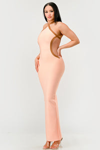 Peaches and Cream Infinity Gown Bandage dress Model wearing a sleek peach maxi dress featuring a halter neckline with contrasting brown trim accents that outline the curves, creating a sophisticated and contemporary silhouette. Perfect for formal events or evening occasions - Rêves Dorés