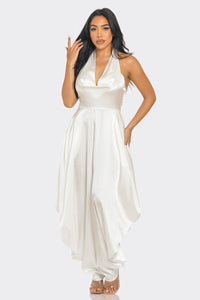 Rêve Dorés Ivory Serenity Jumpsuit | Model wearing an elegant white satin jumpsuit featuring a halter neckline with a draped cowl detail and a flowy silhouette. The sophisticated design exudes timeless glamour, perfect for formal occasions or special events