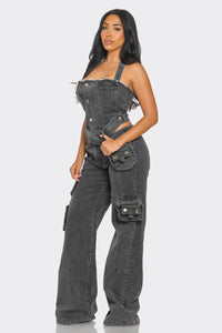 Multi pocket cargo denim jumpsuit. Rêve Dorés Model showcasing a trendy black denim jumpsuit with a strapless design, featuring a belted waist and utility-style pockets for a chic, urban look. The straight-leg fit and rugged detailing make it a perfect statement piece for casual outings or streetwear-inspired ensembles.