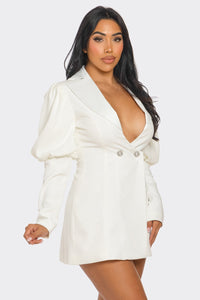 Model wearing a chic white blazer-style mini dress featuring a deep V-neckline, structured shoulders, puffed long sleeves, and decorative rhinestone buttons for a sophisticated and elegant look - Rêve Dorés