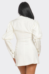 Model wearing a chic white blazer-style mini dress featuring a deep V-neckline, structured shoulders, puffed long sleeves, and decorative rhinestone buttons for a sophisticated and elegant look - Rêve Dorés