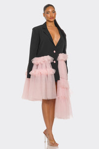 Oversized Tulle Blazer Dress Black and Pink
Model wearing a bold and avant-garde blazer dress in black, featuring a plunging neckline, oversized silhouette, and pastel pink ruffled tulle accents cascading asymmetrically. A statement piece blending edgy tailoring with whimsical femininity, styled with clear heels for a modern touch. - Rêve Dorés